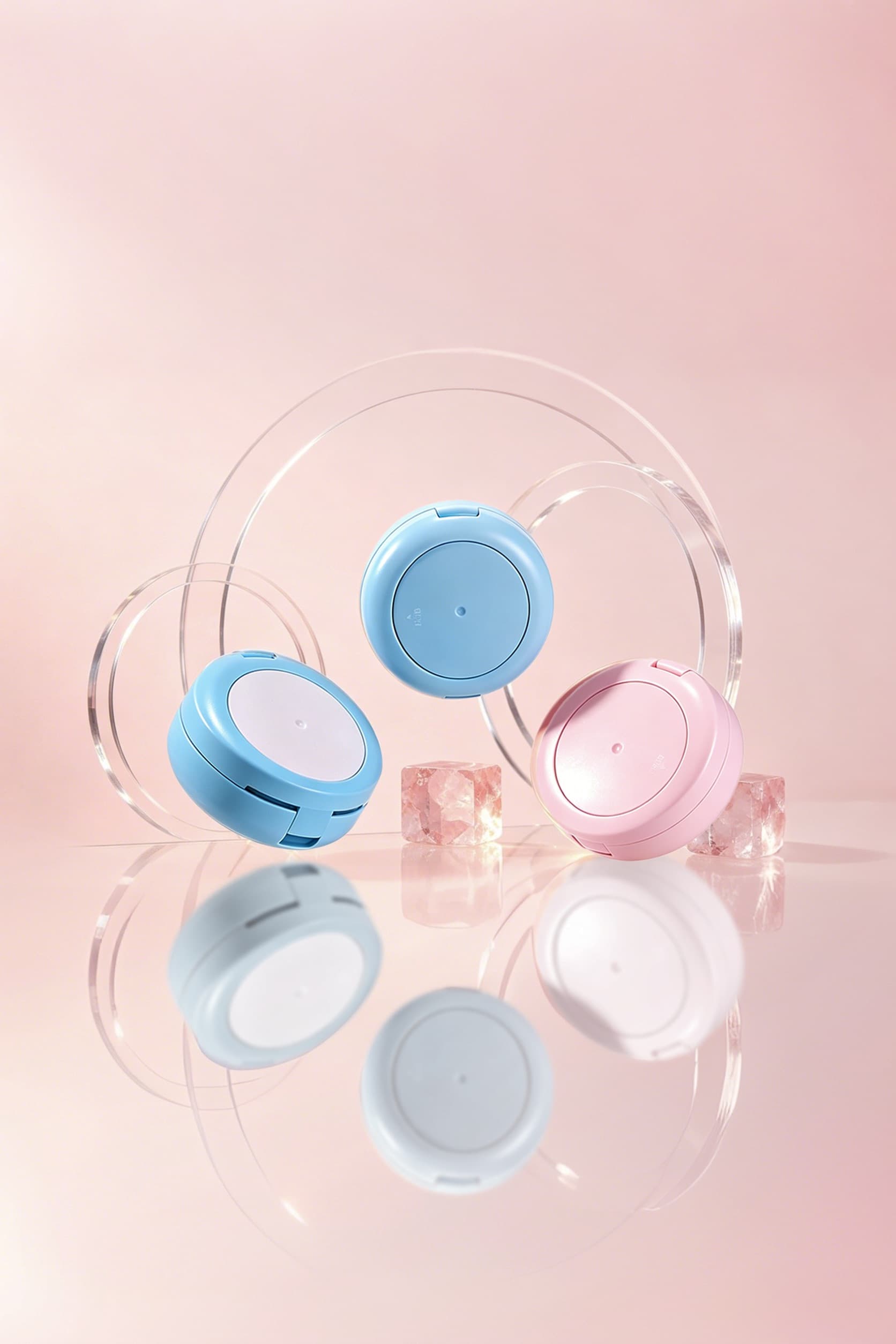 ตลับกลมสีฟ้าและชมพูบนฉากโทนชมพูพร้อมแผ่นอะคริลิกใส